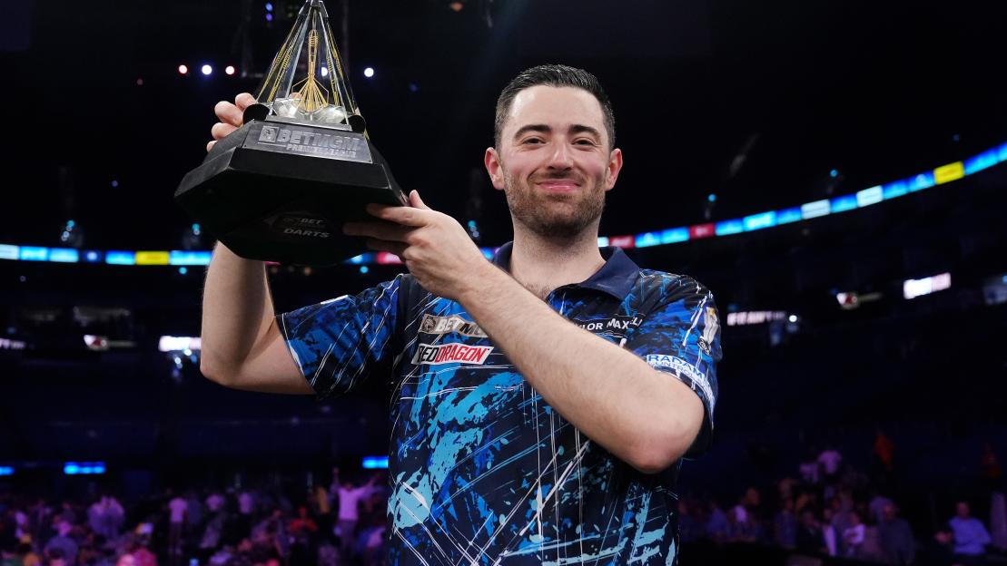 Luke Humphries celebrates with the BetMGM Premier League Play-Offs trophy.