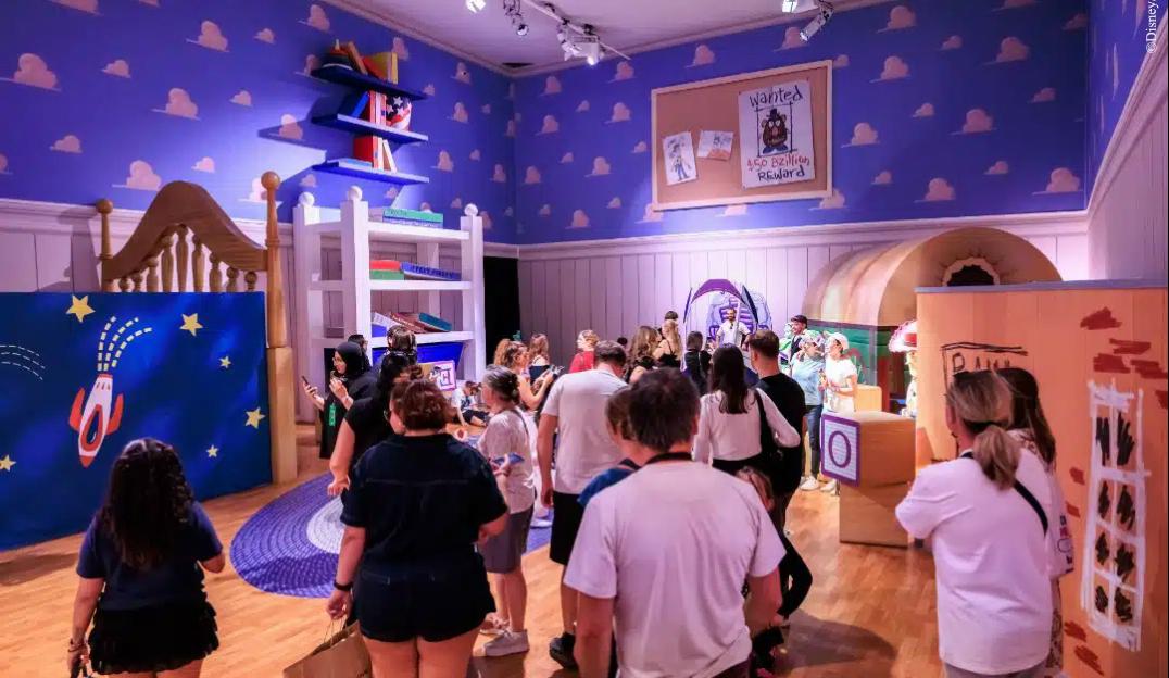 People experiencing a Pixar immersive exhibit designed to look like Andy's room from Toy Story.