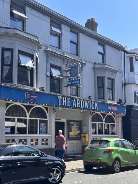 The Ardwick pub, with a person walking towards its entrance.