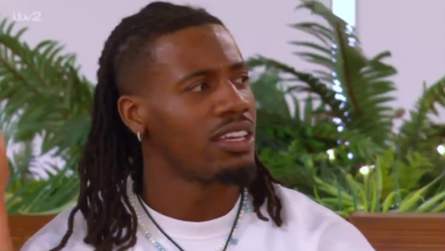 A man with dreadlocks and a white t-shirt.