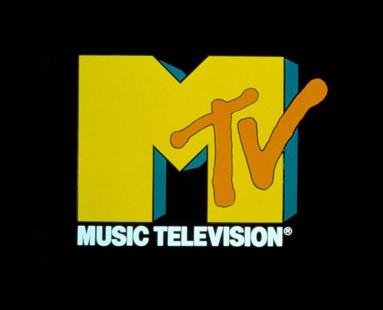 The original MTV logo from 1981, featuring a large yellow 'M' with a smaller orange 'TV' drawn on top, and "MUSIC TELEVISION" written below.