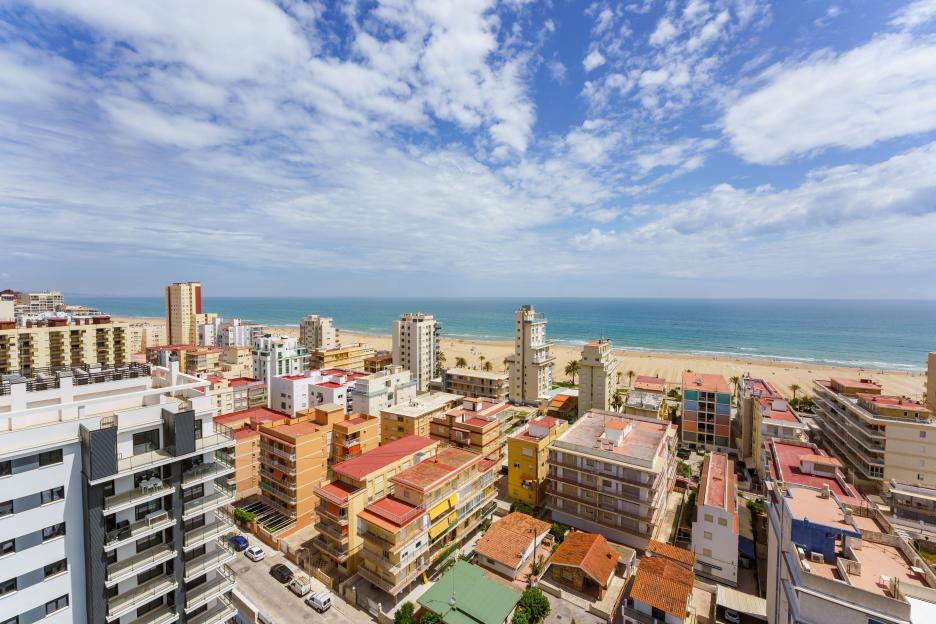 High-angle panoramic view of Playa de Gandia, Valencia, Spain, showing urban buildings along the Mediterranean coast.