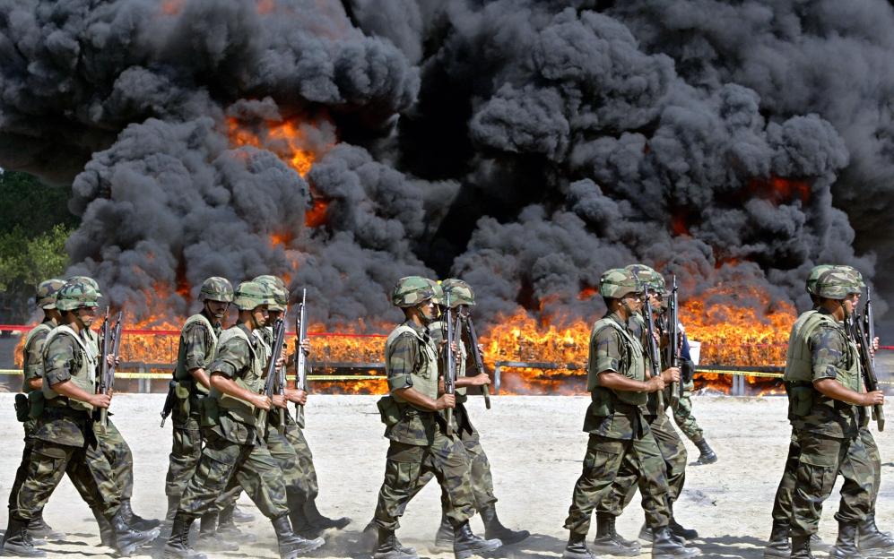 Mexican soldiers walk next to the site o