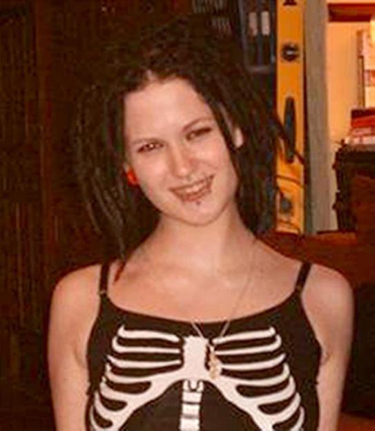 Sophie Lancaster, a young woman with dark dreadlocks and facial piercings, wearing a black top with a white skeleton design.
