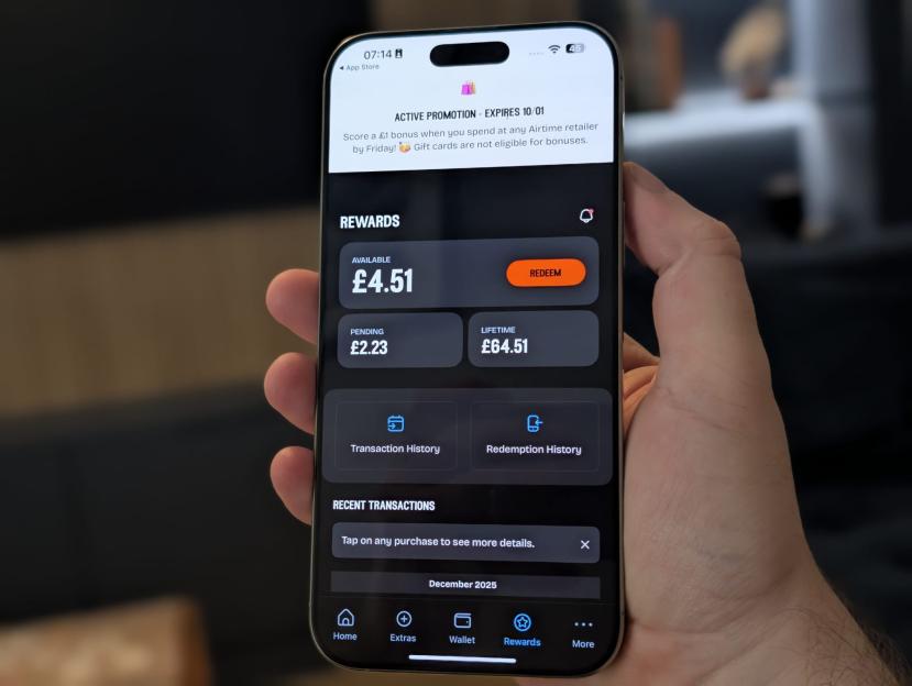 A hand holding a smartphone displaying an app with rewards information, showing an active promotion, available rewards of £4.51, pending rewards of £2.23, and lifetime rewards of £64.51.
