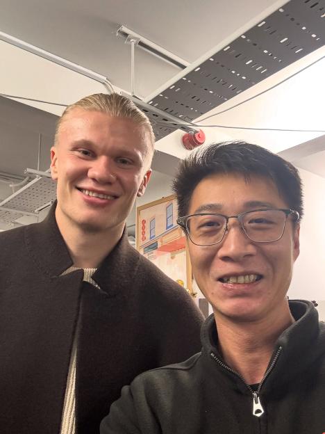 Footballer Erling Haaland taking a selfie with a restaurant staff member.