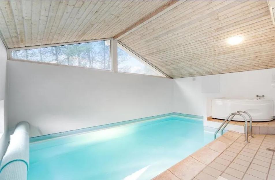 Indoor swimming pool with a hot tub in a chalet in Denmark.