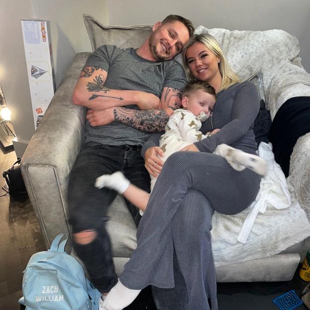 Hollyoaks star Alfie Browne-Sykes, his fiancée Aimée Scott, and their son on a couch.