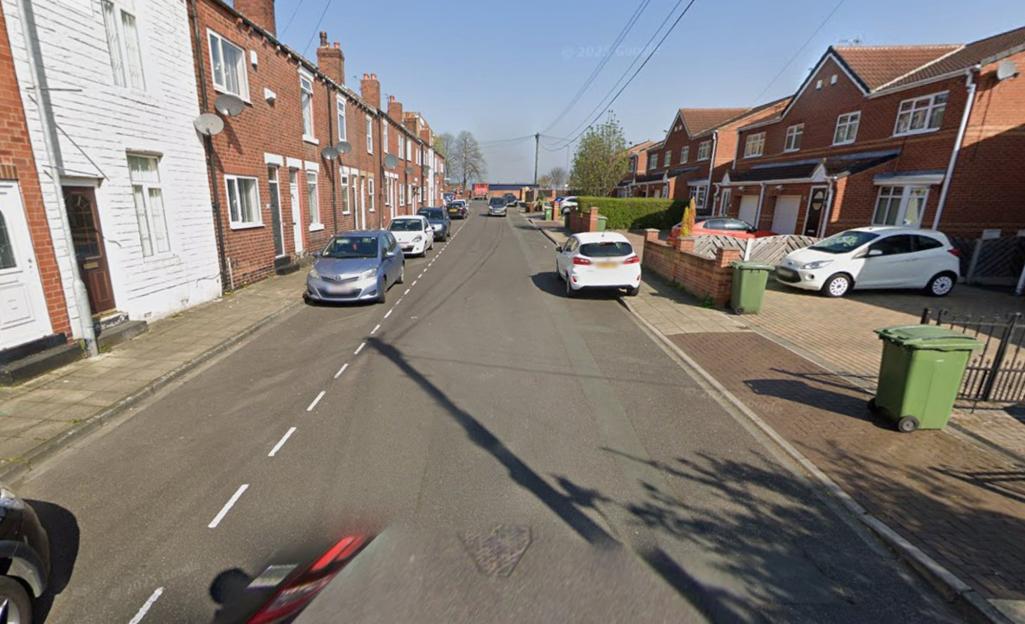 Manor Grove in Castleford with houses lining both sides of the street and cars parked along the curb.