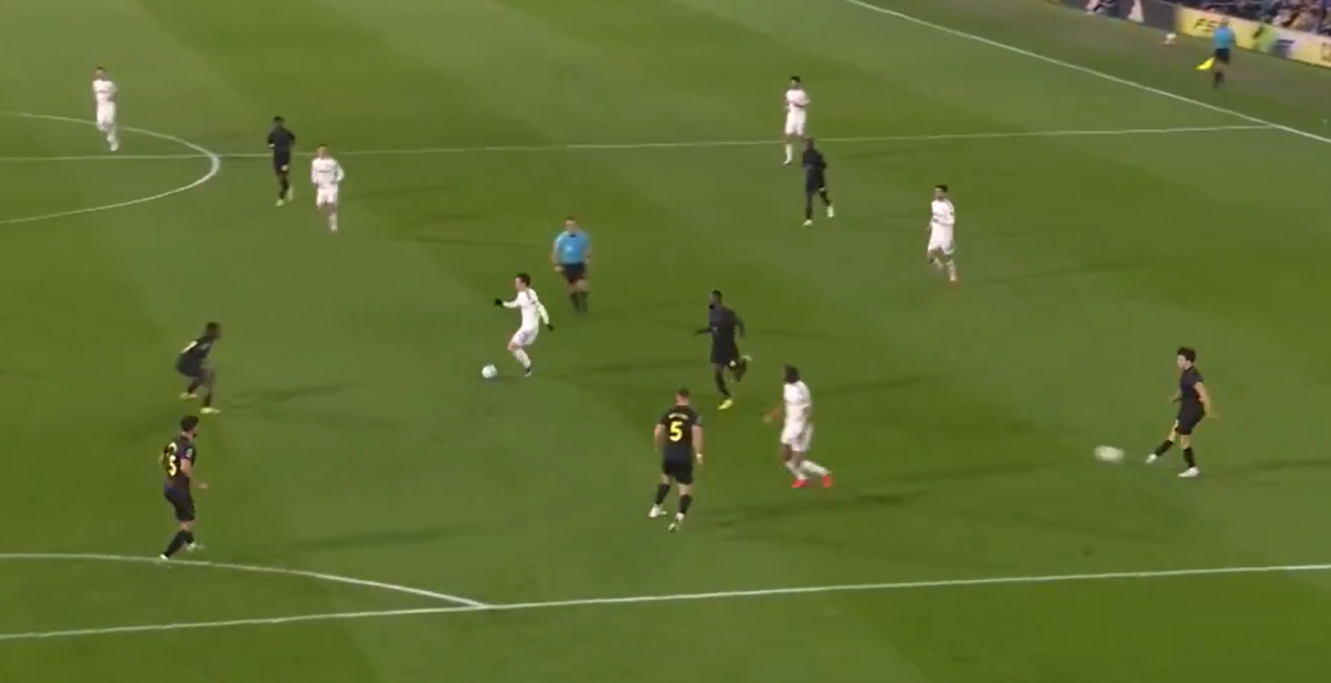 A soccer match in progress with players in white and black uniforms.
