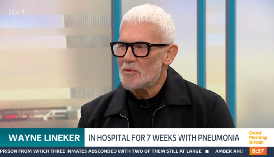 Wayne Lineker in a black jacket and glasses being interviewed on ITV's Good Morning Britain, with a caption stating he was "IN HOSPITAL FOR 7 WEEKS WITH PNEUMONIA."