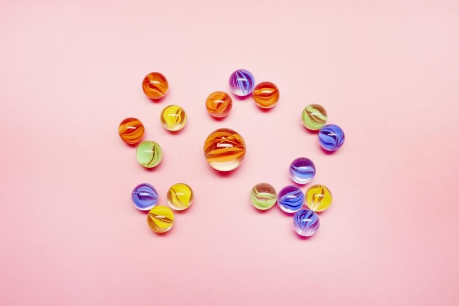 Marbles on pink background, small versus large