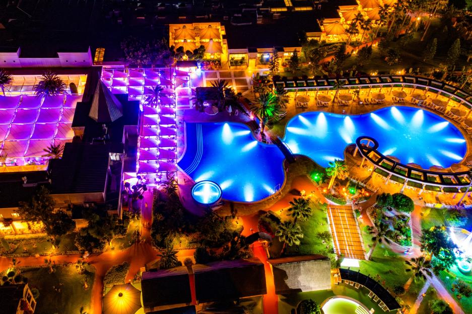 Aerial view of Tui Magic Life resort at night, with brightly lit pools and buildings in Belek, Turkey.