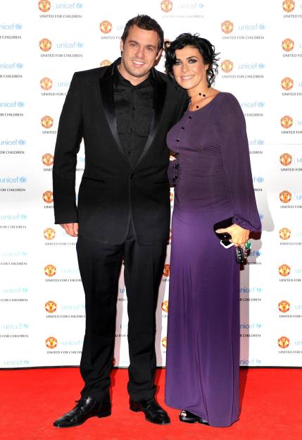 Kym Marsh and Jamie Lomas posing on a red carpet with a backdrop of Manchester United and UNICEF logos.