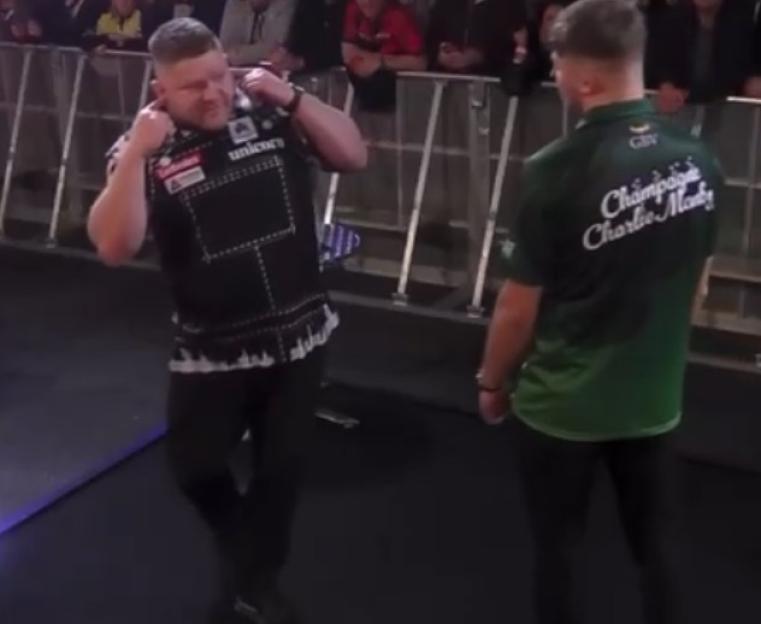 Darts player Nathan Aspinall with his fingers in his ears.