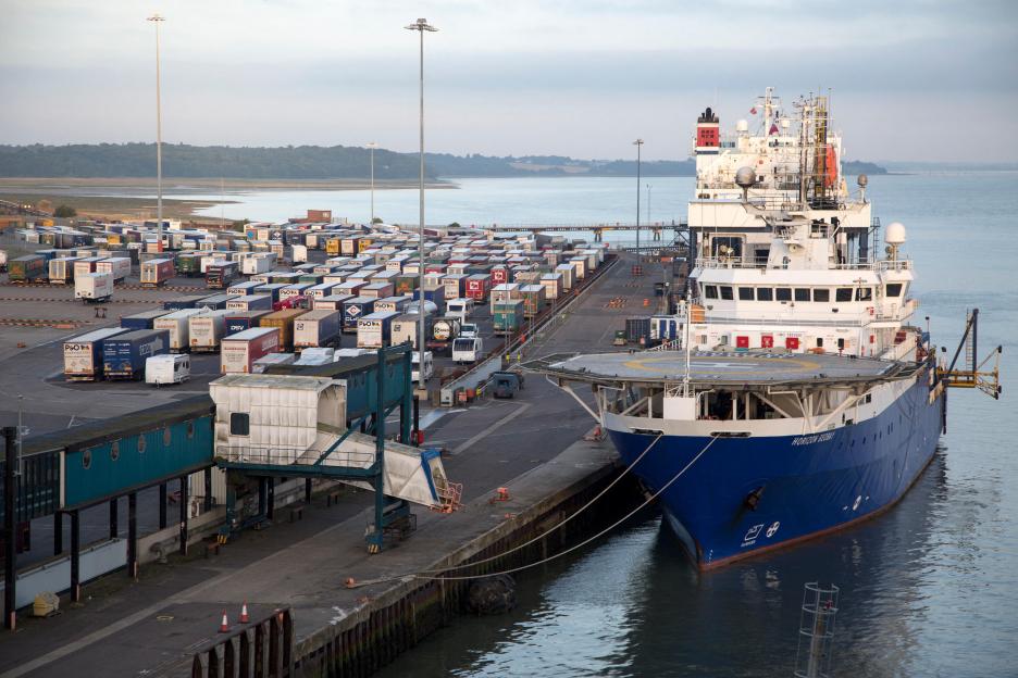 A Horizon Geobay supply ship docked at the Port of Harwich, with rows of parked HGVs and trailers.