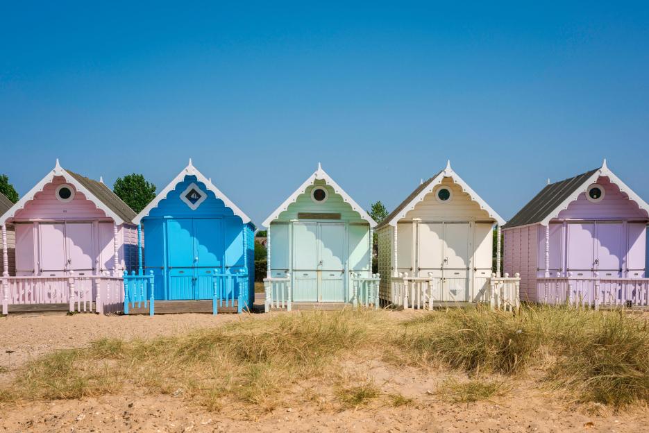 Colorful beach huts in West Mersea, Essex, England, UK.