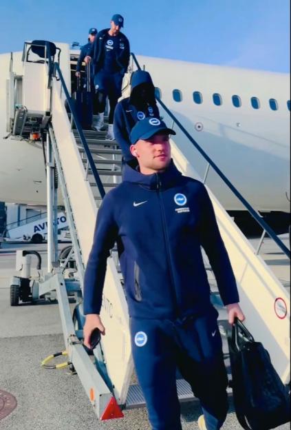 Brighton & Hove Albion FC team members disembarking an airplane.