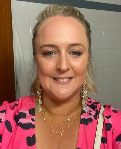 Woman in pink leopard print dress wearing jewelry.