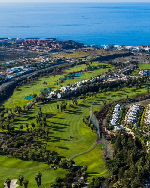 Aerial view of the Golf Costa Adeje course in Tenerife, with the ocean in the background.