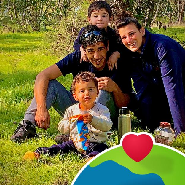 A family with two children enjoying a day out in a field, with a heart icon partially covering the bottom right.