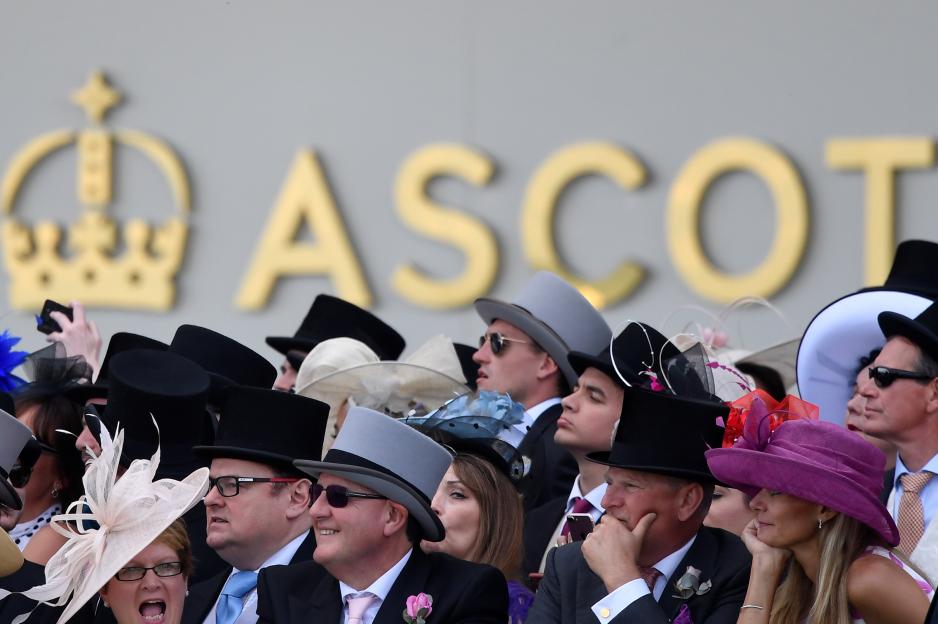 Racegoers watching a horse race at Ascot.