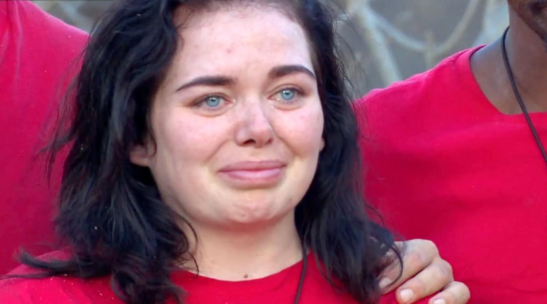 Scarlett Moffatt, with tears in her eyes, wears a red shirt.
