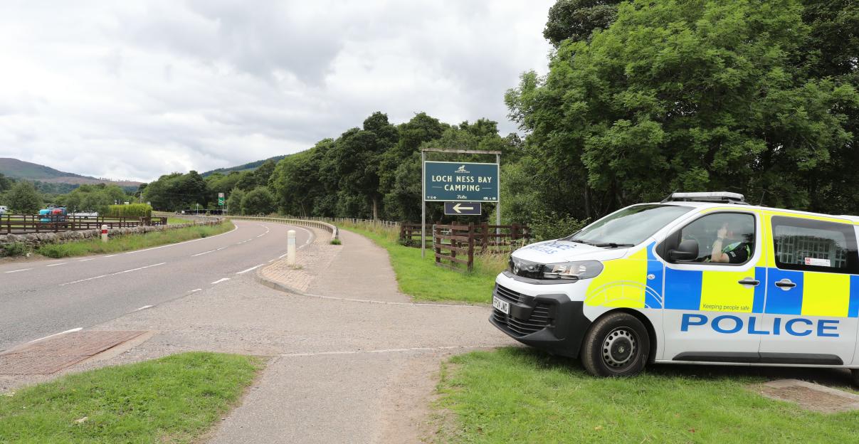 Police vehicle parked at the entrance to Loch Ness Bay Camping site.