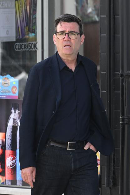 Mayor Andy Burnham of Manchester walks on a high street.