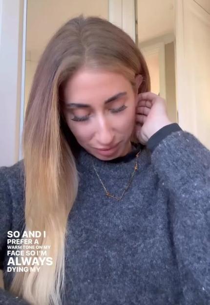 Woman with long blonde hair, wearing a gray sweater and a necklace, talking about preferring warm tones on her face.