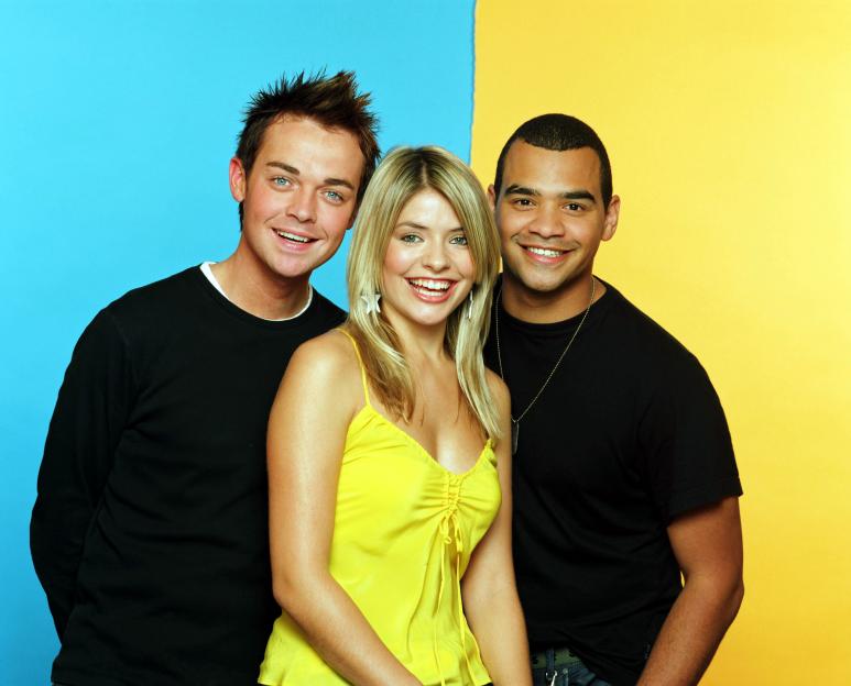Stephen Mulhern, Holly Willoughby, and Michael Underwood smiling at the camera.