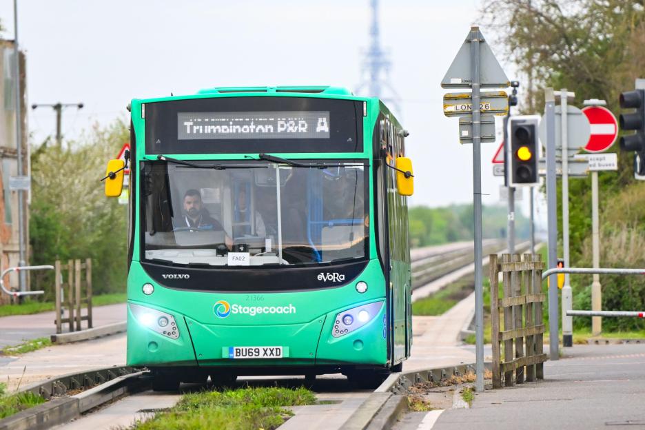 Green Stagecoach guided bus at the junction of B1050 on the Cambridgeshire Guided Busway.