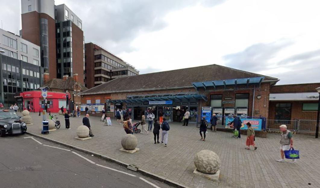 Exterior view of Bromley South Station with people entering and exiting the building.