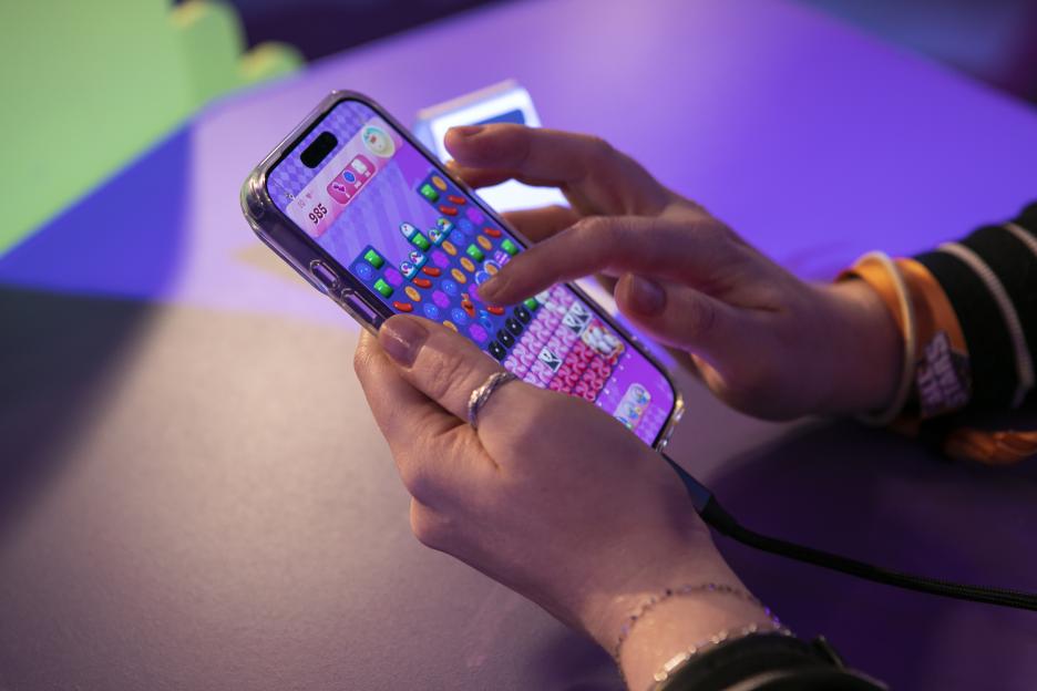 A person playing Candy Crush on a mobile phone.