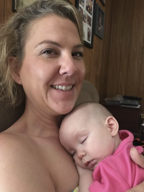 Rachel Bond smiling with her great-niece Annie sleeping on her chest.