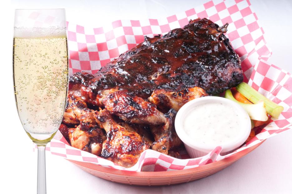 Collage of champagne next to a basket of ribs, chicken wings, dipping sauce, and vegetables.