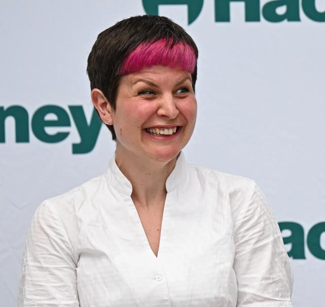 Zoë Garbett smiling with a backdrop showing the Hackney logo.