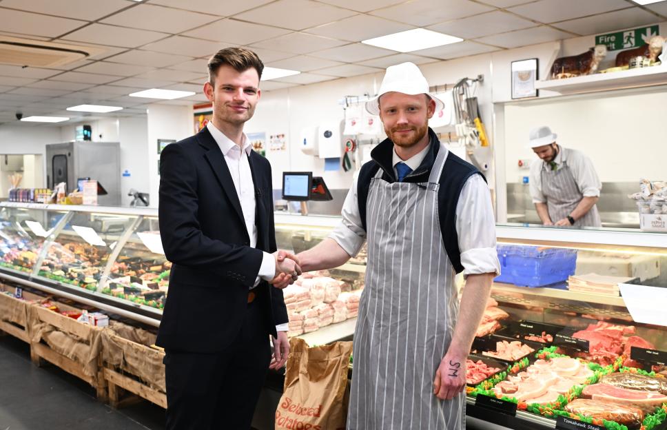Reporter Sam Creed shakes hands with a butcher in Countrystyle Meats Farmshop.