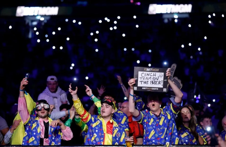 Fans in fancy dress hold up a sign reading "Cinch Team on the Beer!" during the Premier League playoffs in London.