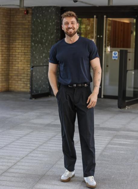 Sam Thompson smiling while standing outside.