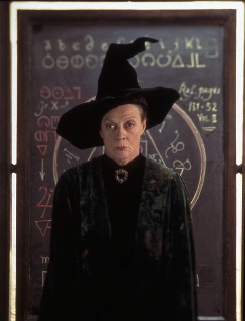 a woman in a black coat is holding a wand