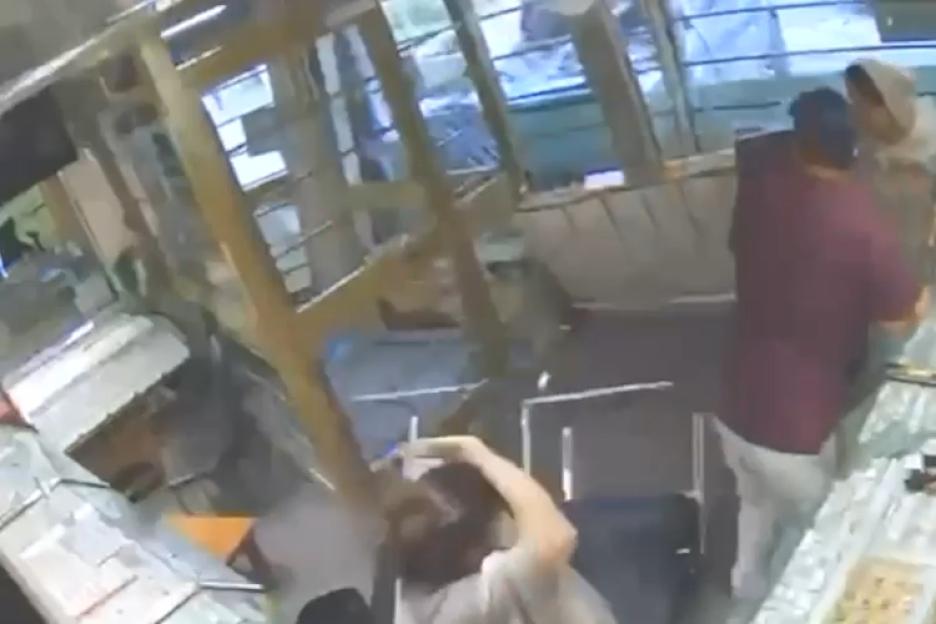 Security camera footage showing a 4x4 crashing through a jeweller's window as two people stand inside the damaged shop.