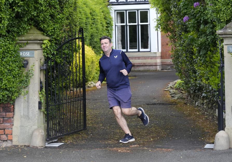 Andy Burnham, Mayor of Greater Manchester, running out of his house in Warrington.