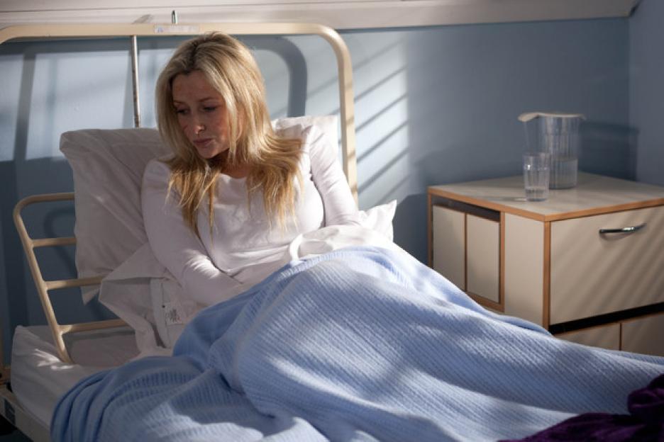 Gemma Merna in Hollyoakes sitting in a hospital bed.