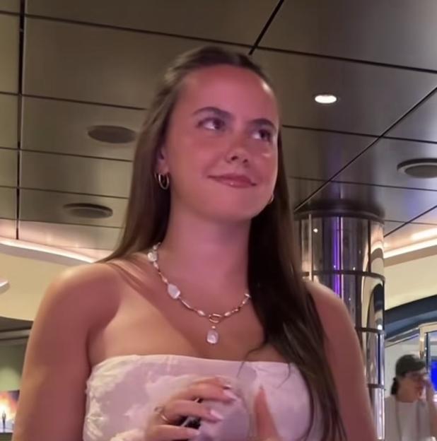 Spencer Barbosa wearing a white strapless top and a pearl necklace.