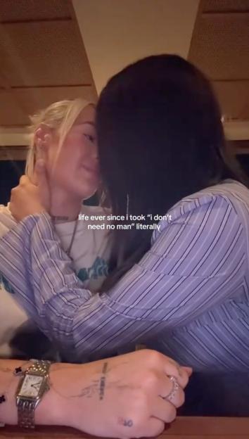 Two women kissing, with text overlay "life ever since i took "i don't need no man" literally".