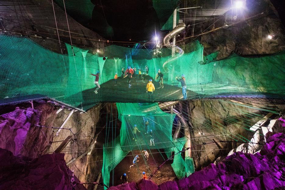 People bouncing on trampolines in an underground cave at Bounce Below.