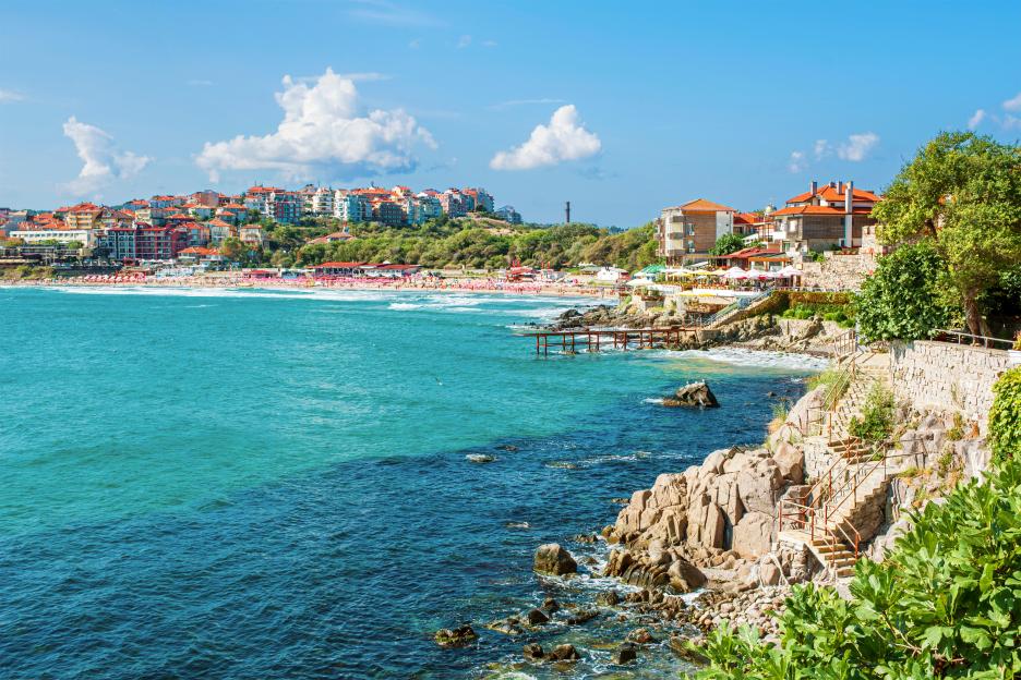 Coastline of Sozopol, Bulgaria, with a beach and buildings along the shore.