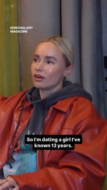A person with blonde hair wearing a red jacket over a grey hoodie, with the text "So I'm dating a girl I've known 13 years."