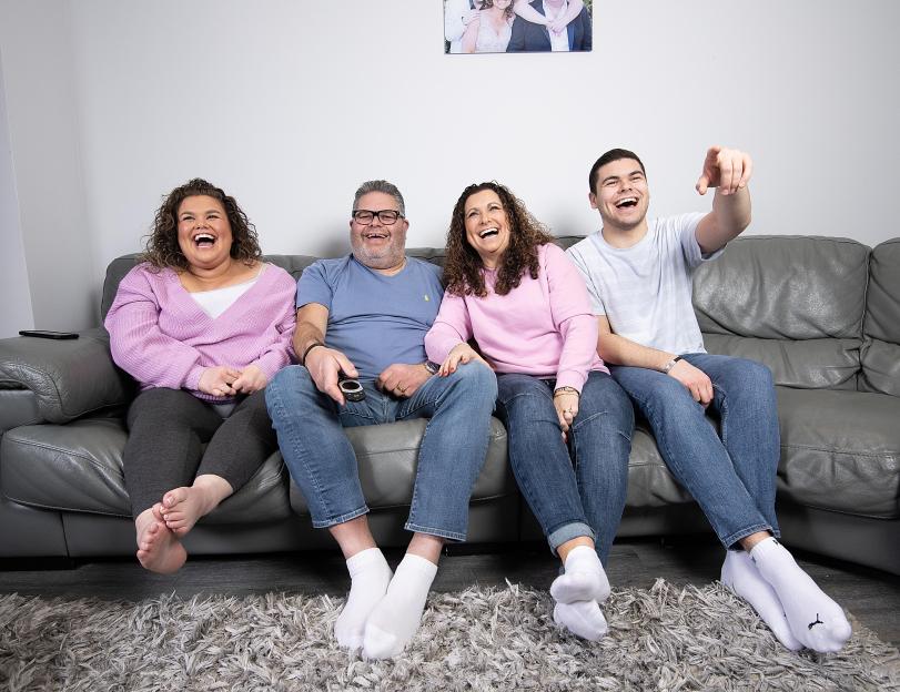 The Tapper family on a couch watching television.